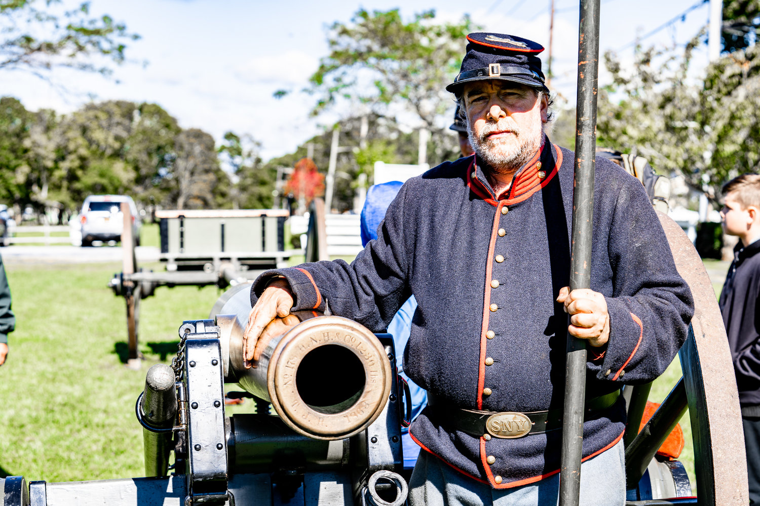 A Union soldier poses by a cannon.